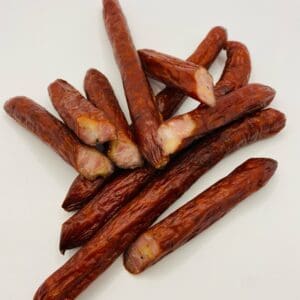 A pile of sausage links on top of a white surface.