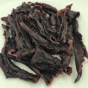 A white plate topped with meat covered in sauce.